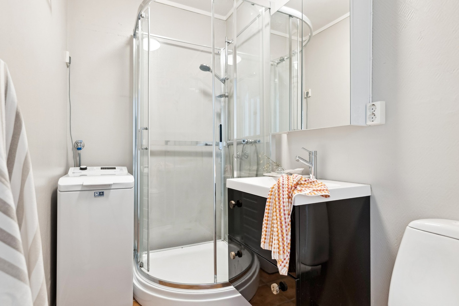 Badet er utstyrt med dusjkabinett, toalett, servant og opplegg for vaskemaskin. Galleribilde