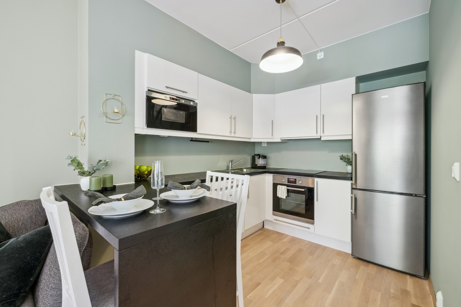 Norema kjøkkeninnredning med fabrikklakkerte glatte fronter. Kjøkkenet er utstyrt med delvis integrerte hvitevarer Galleribilde