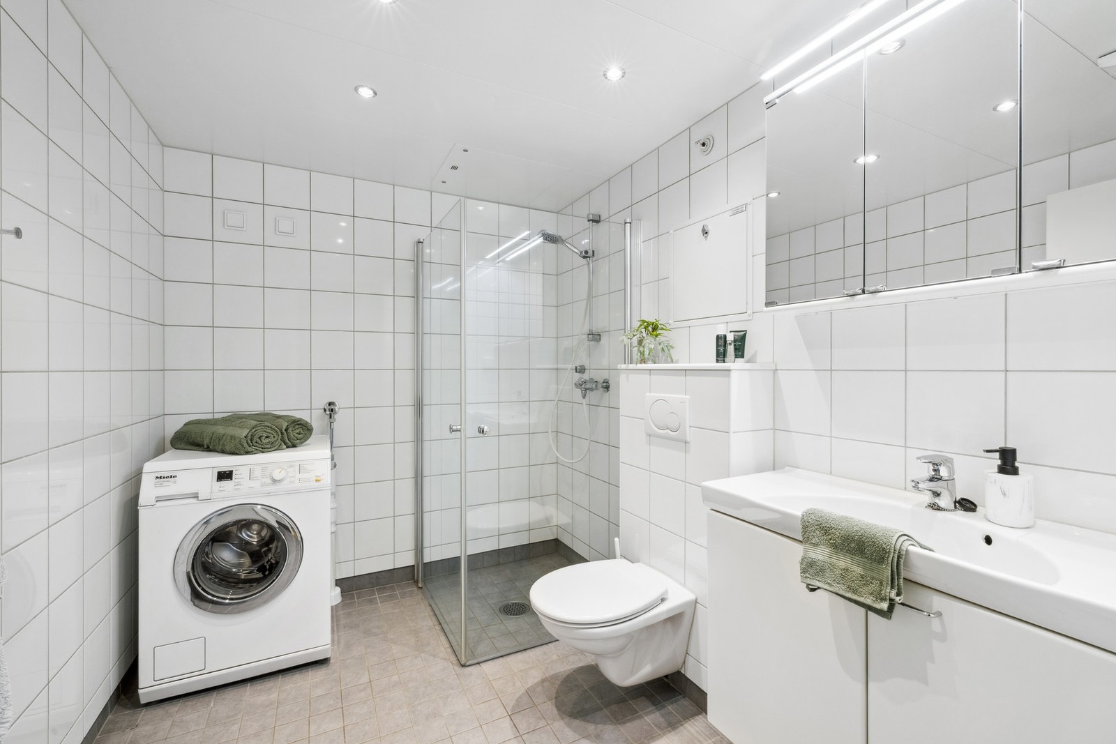 Badet er romslig og har varmekabler i gulv, downlights i himling, servantseksjon med stor servant og overskap Galleribilde