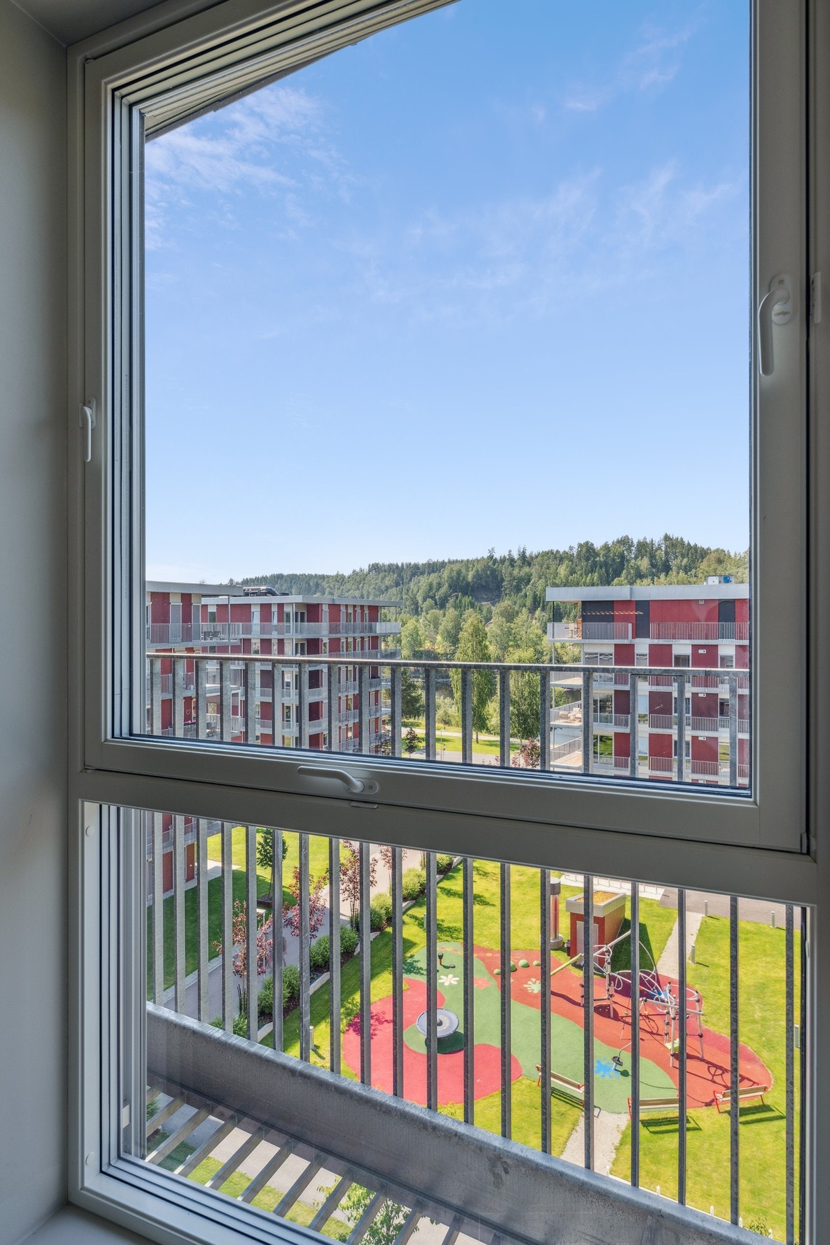 Fra vinduet i 6. etasje har du utsyn over det frodige fellesområdet med lekeplass og grønne plener - perfekt for rekreasjon. Galleribilde