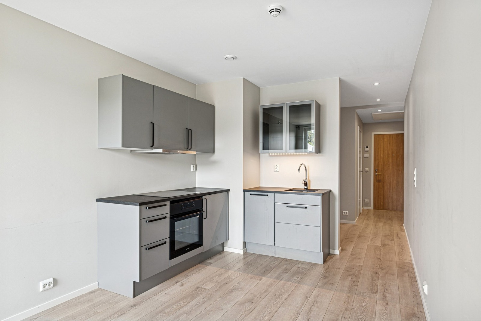 Moderne kjøkkeninnredning fra Sigdal i stilren gråtone, med integrert hvitevarer. Galleribilde