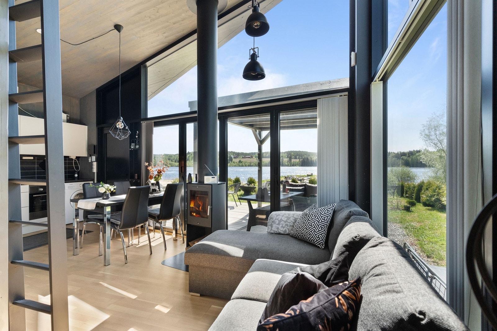 Stuen har store vindusflater som slipper inn lys fra flere sider og gir en følelse av å være i ett med naturen. Galleribilde