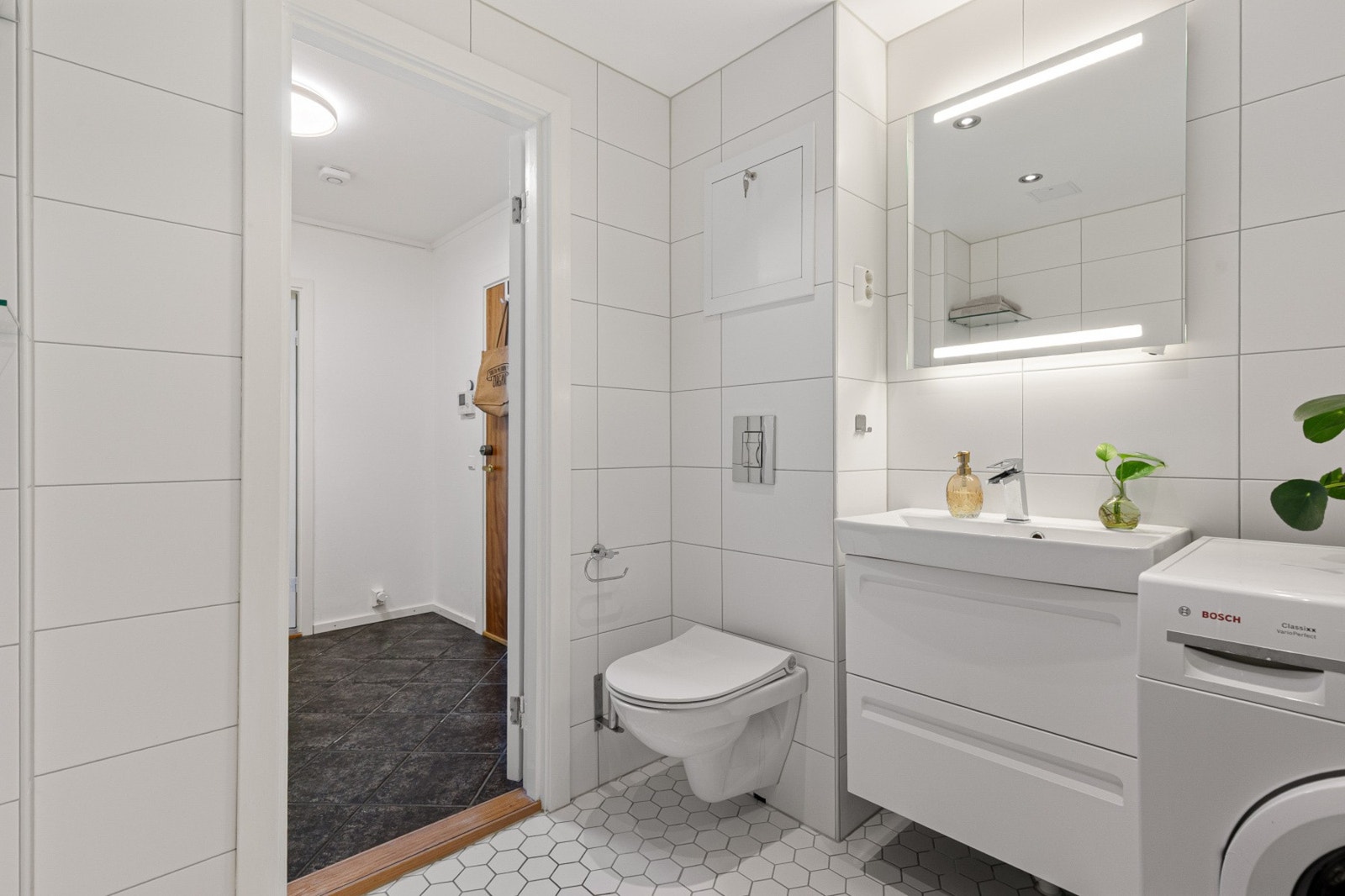 Mekanisk avtrekk, vegghengt toalett, servant og speil med lys. Galleribilde