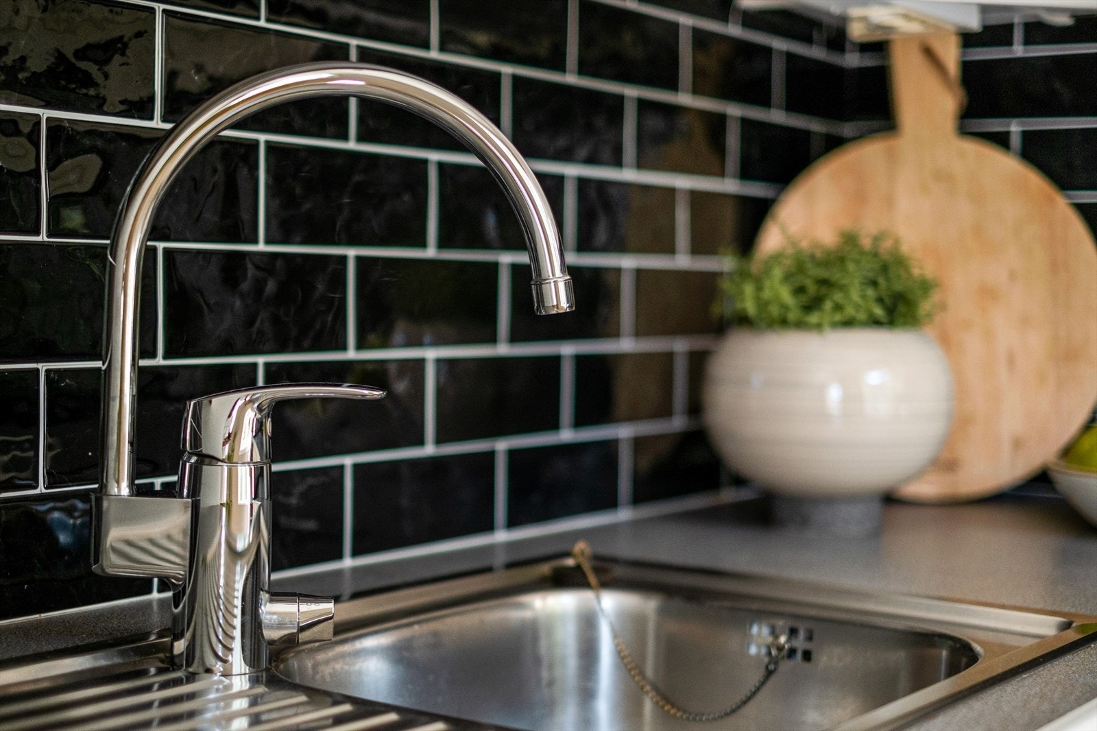 Kjøkkenet er utstyrt med hvite malte fronter, nedfelt kum, komfyr, integrert kombiskap, integrert oppvaskmaskin, laminat benkeplate og ventilator i overskap Galleribilde