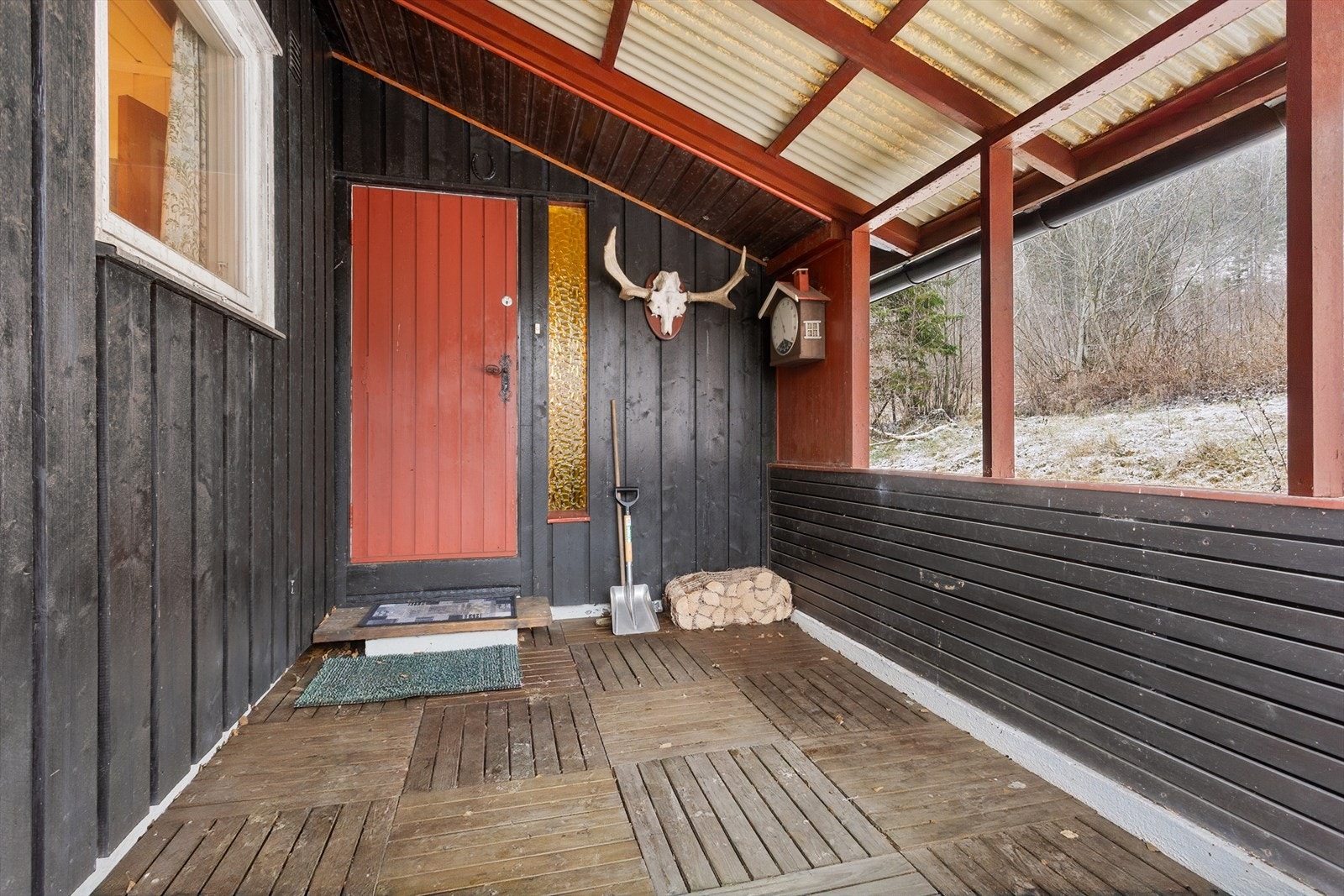 Via et overbygget inngangsparti kommer du inn til hytta. Galleribilde