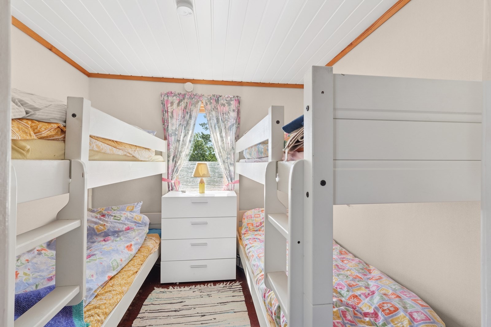 Soverom med fire sengeplasser og vindu som slipper inn godt med dagslys - både funksjonelt og koselig Galleribilde