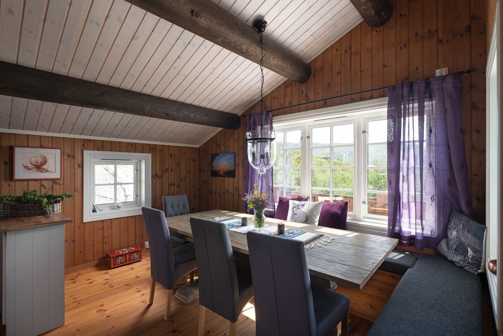 Kjøkkenet har en koselig sittegruppe med spisebord og benker Galleribilde