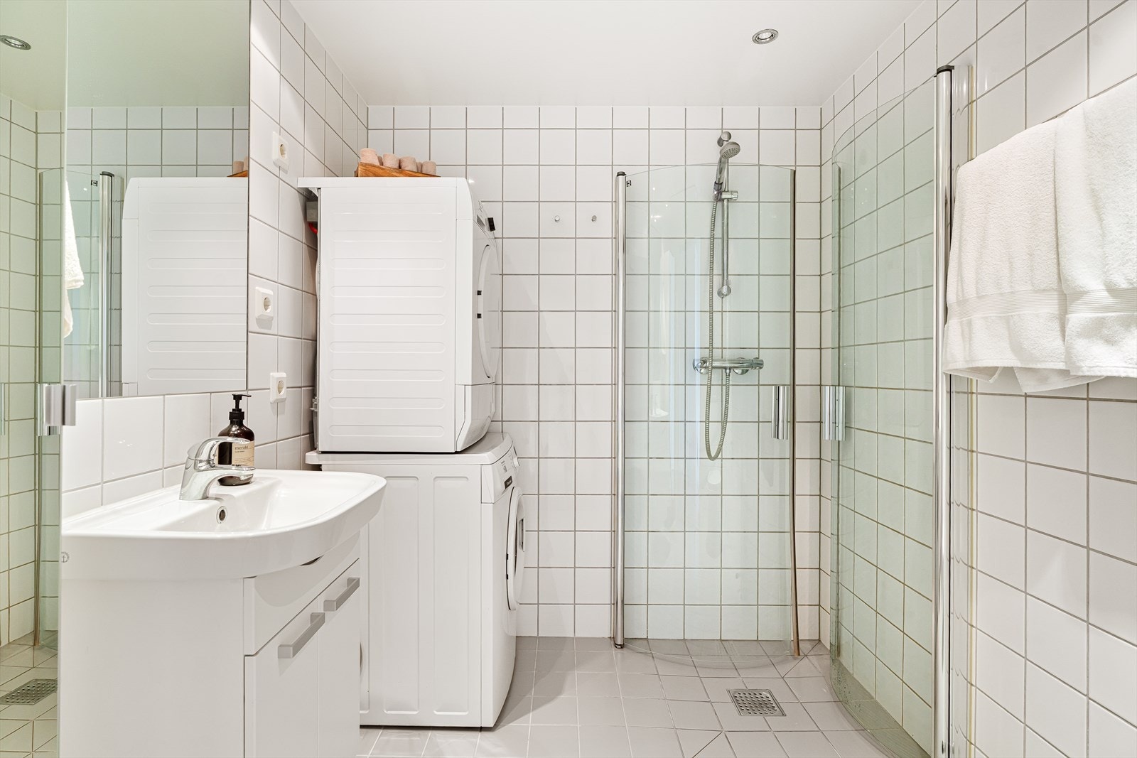 Servant med underskap og armatur samt speil over. Opplegg til vaskemaskin og tørketrommel som medfølger. Galleribilde