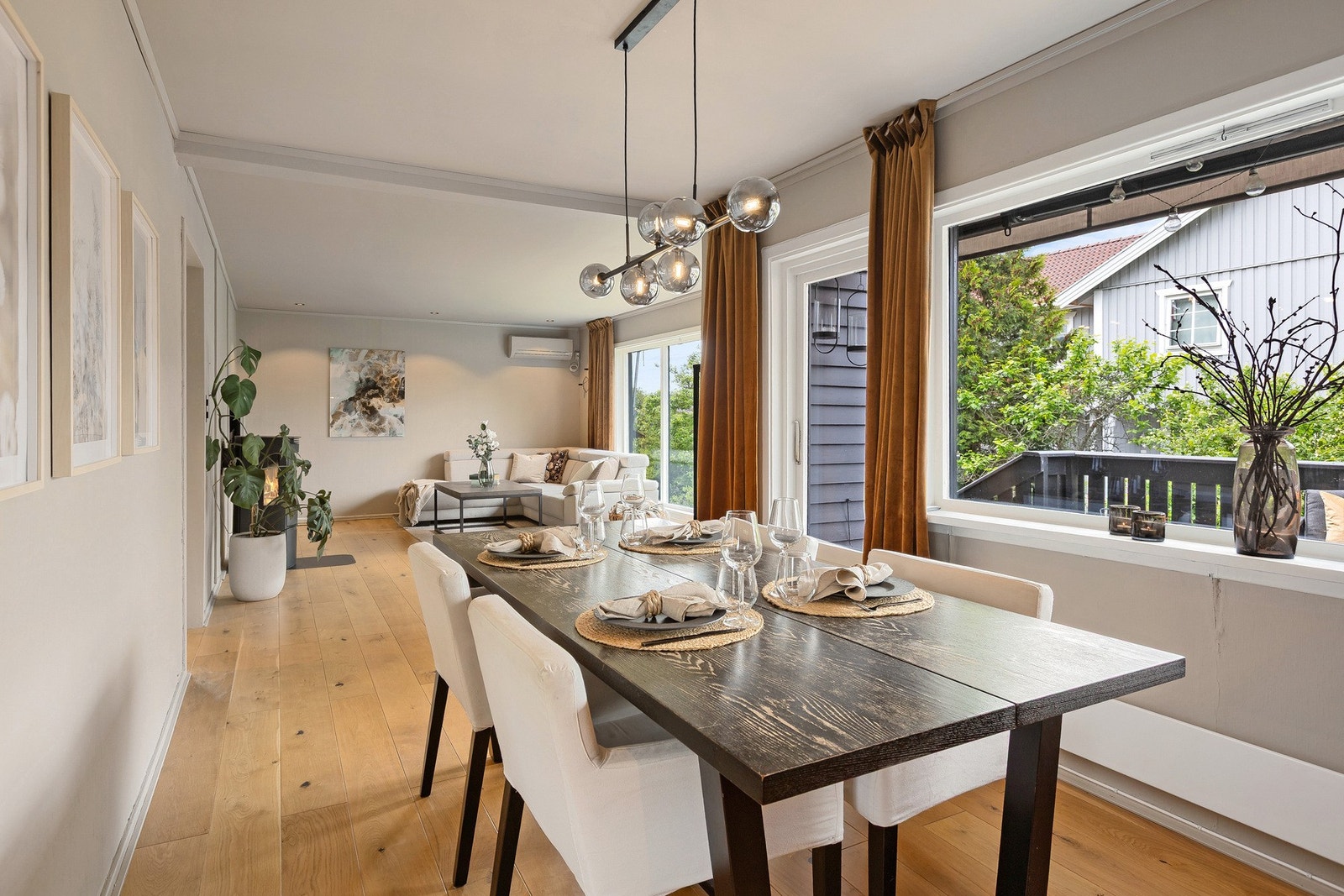 Åpen, lyst og trivelig oppholdsrom bestående av avdeling for sofa og spisestue. Galleribilde