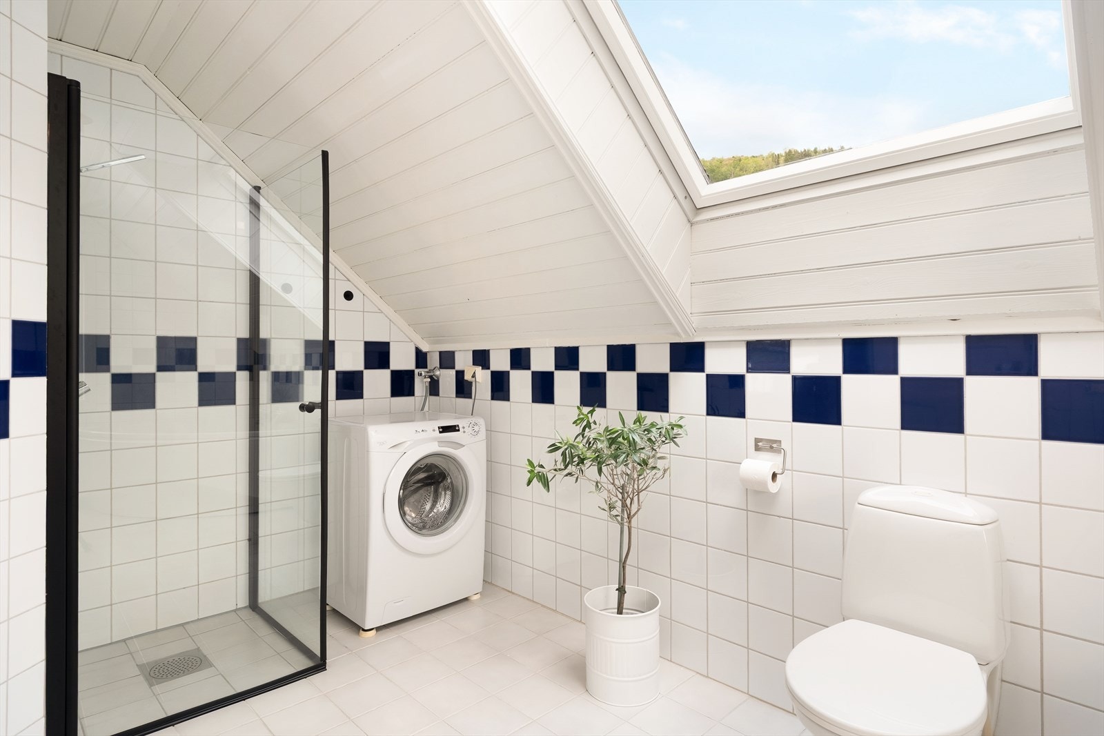 Badet er kombinert med vaskerom og har flis og elektriske varmekablar i golv, og flis på veggar. I himling er det måla panel. Galleribilde