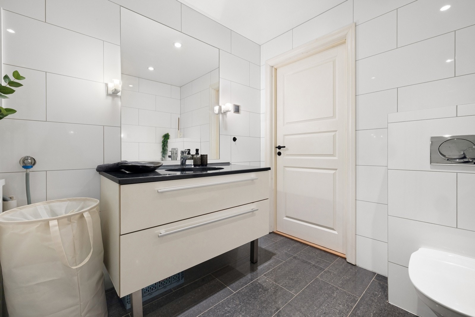 Innredning består av innredning med nedfelt servant, veggmontert toalett, dusjvegger og opplegg for vaskemaskin Galleribilde