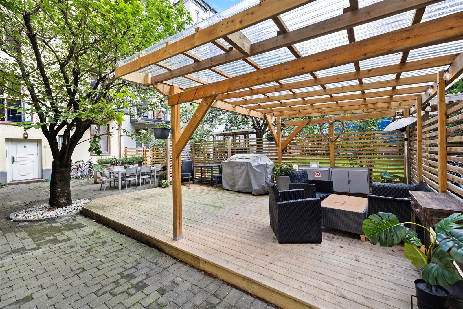 Bakgården er pent anlagt med gjennomtenkte detaljer som skaper en lun og innbydende atmosfære. Her finner du koselige benker og hagemøbler, perfekt for hyggelige sammenkomster Galleribilde