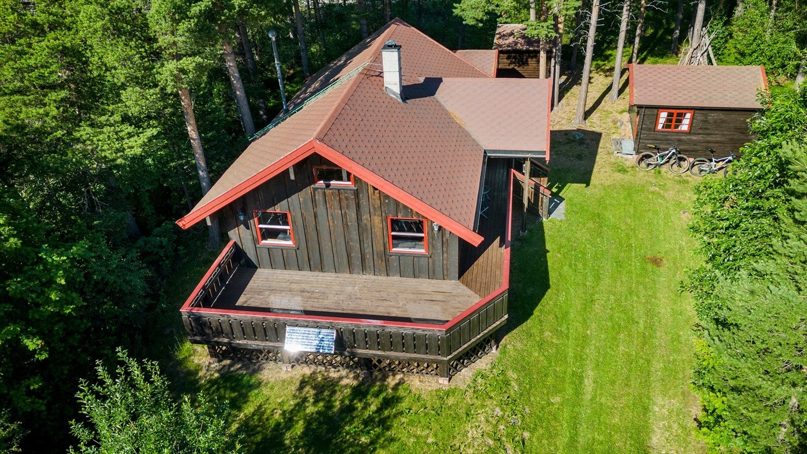 Tomten ligger fint i terrenget, omgitt av skog og natur. Galleribilde