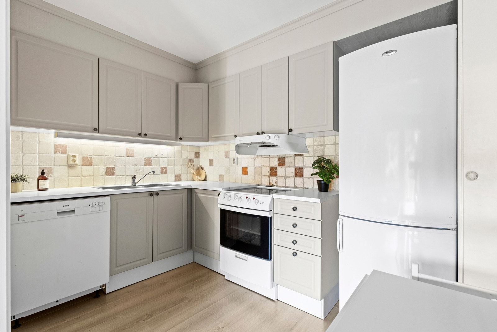 Pent og velholdt kjøkken med profilerte fronter og benkeplate i laminat. Galleribilde