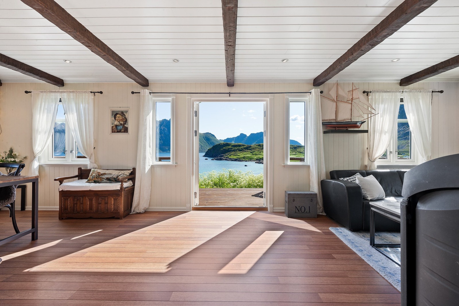 Lys og fin stue med store vindusflater som slipper inn rikelig med naturlig lys og gir deg muligheten til å nyte den fantastiske utsikten. Galleribilde