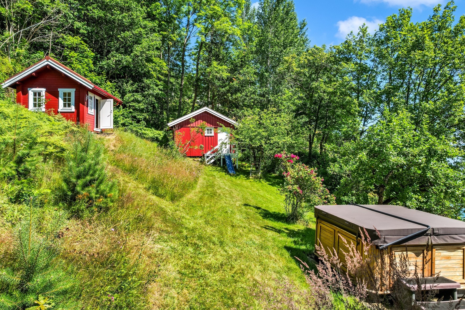 Hagen er pent opparbeidet med frukttrær, blomsterbed og store gressplener som inviterer til både lek og avslapning. Galleribilde