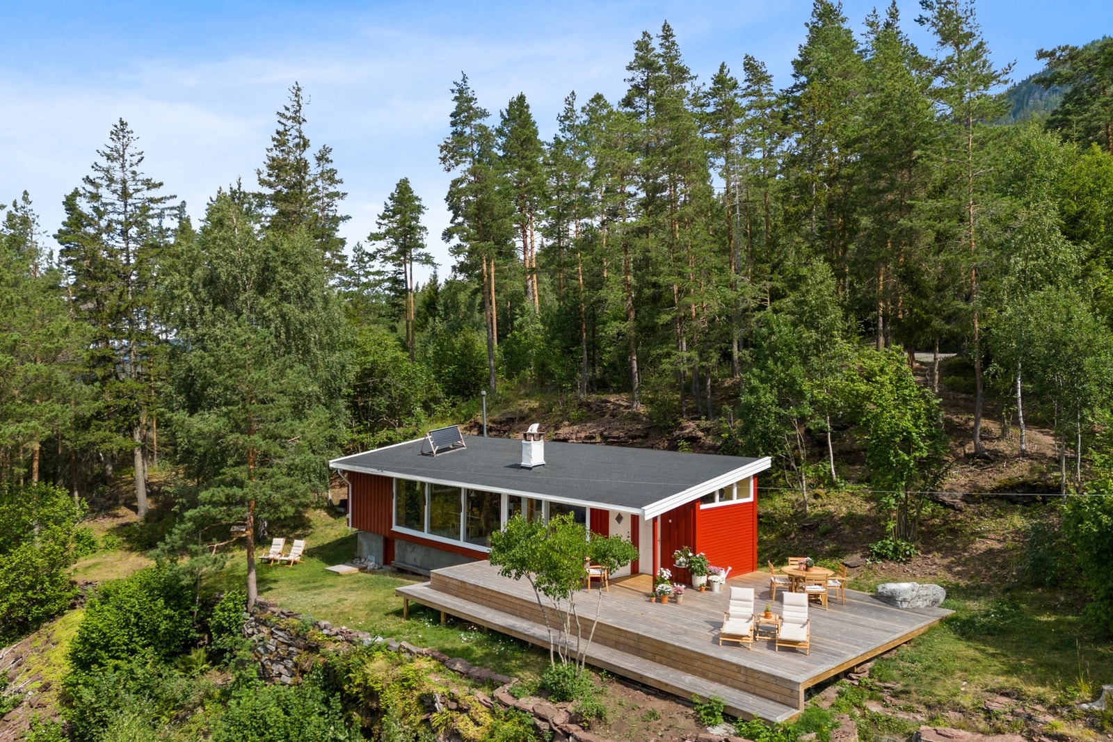 Hytta ligger lunt til i terrenget, omkranset av natur og med storslått utsikt - en perfekt kombinasjon av skjermet og åpent. Galleribilde