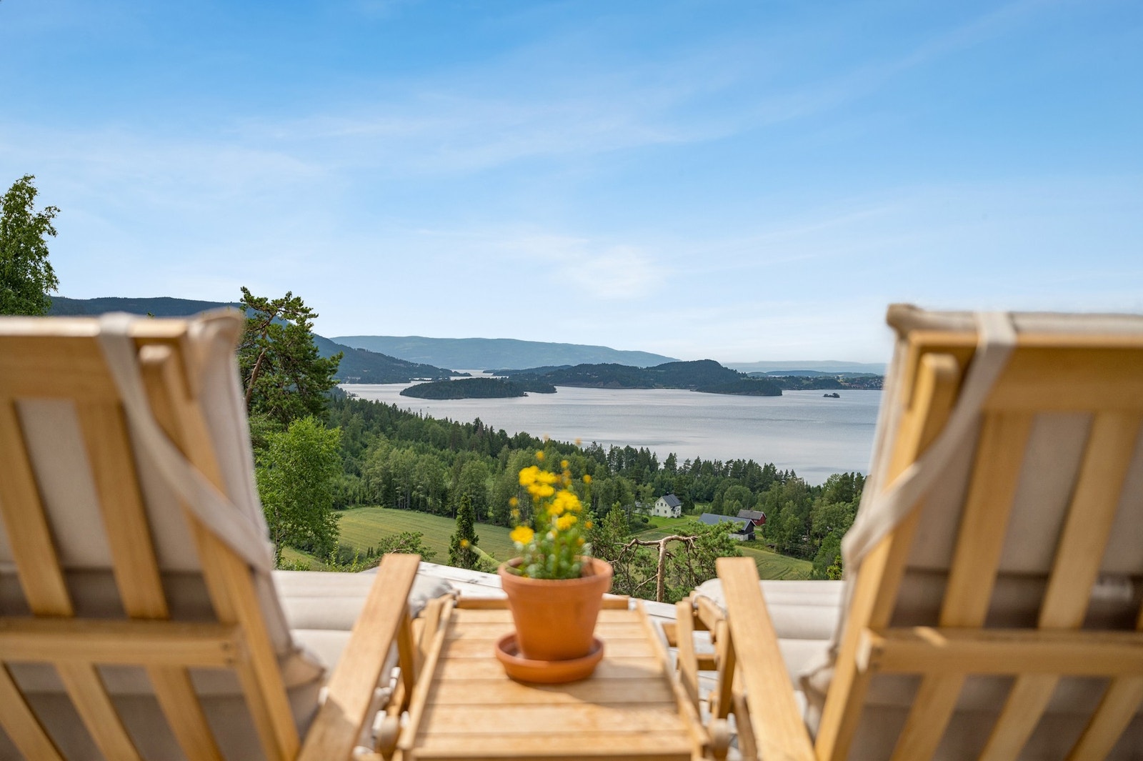 Et utsyn som må oppleves - Steinsfjorden glitrer i sommersolen, omkranset av grønne åser og fjell i horisonten. Galleribilde