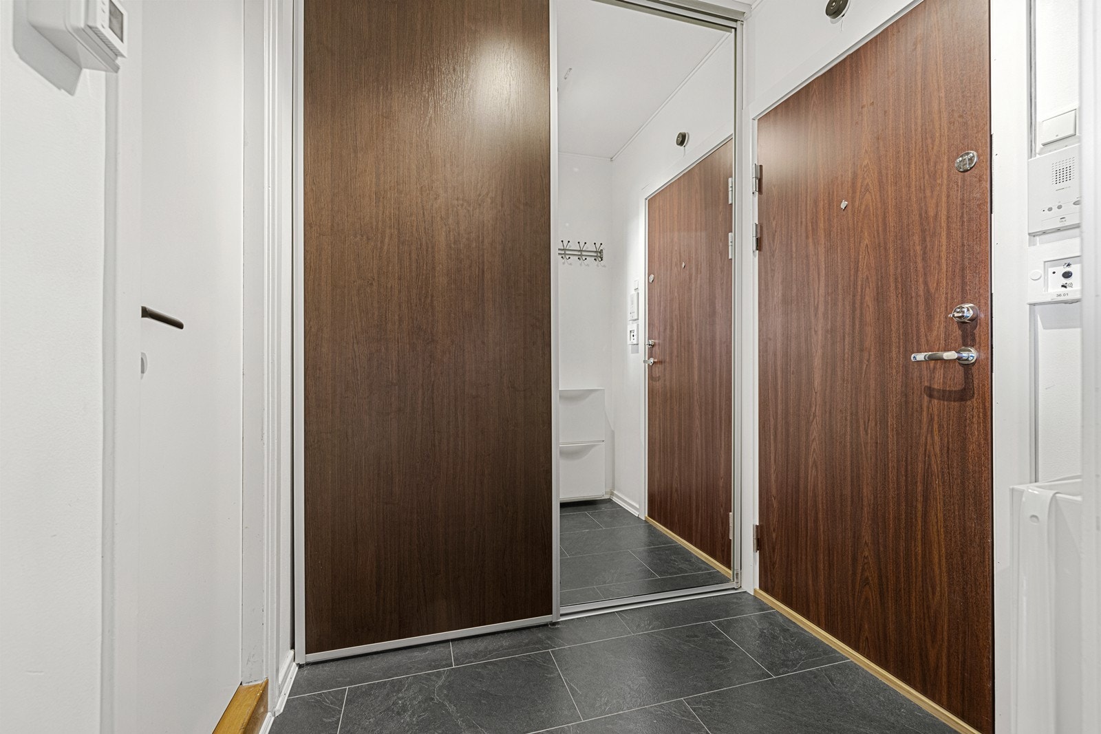Entréen ønsker deg velkommen med laminatgulv og moderne sikkerhetsdør fra Swedoor. Galleribilde