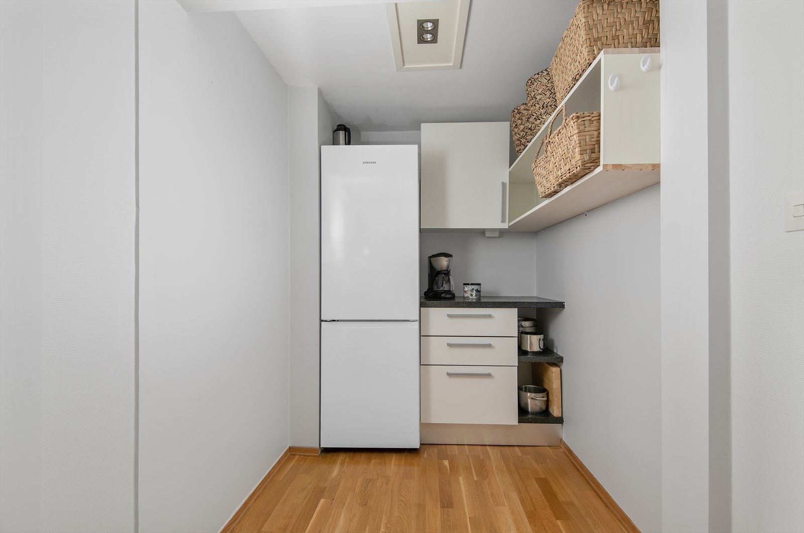 Kombinert kjøl- og fryseskap samt ekstra benkeplass på den andre veggen Galleribilde