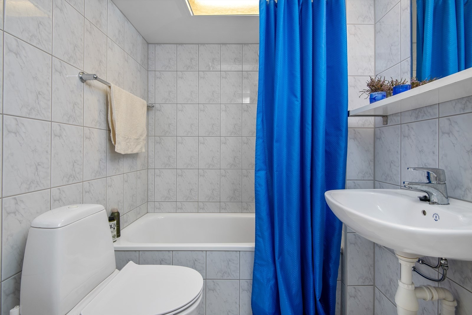 Bad et er flislagt, har gulvvarme og nødvendig garnityr Galleribilde