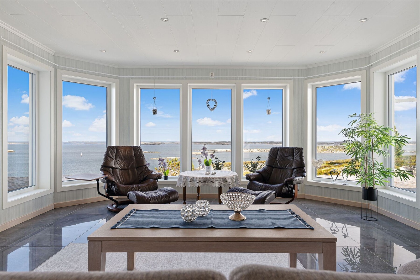 Den åpen, romslige stue-kjøkkenløsningen kan by på store vindusflater med upåklagelig sjøutsikt Galleribilde