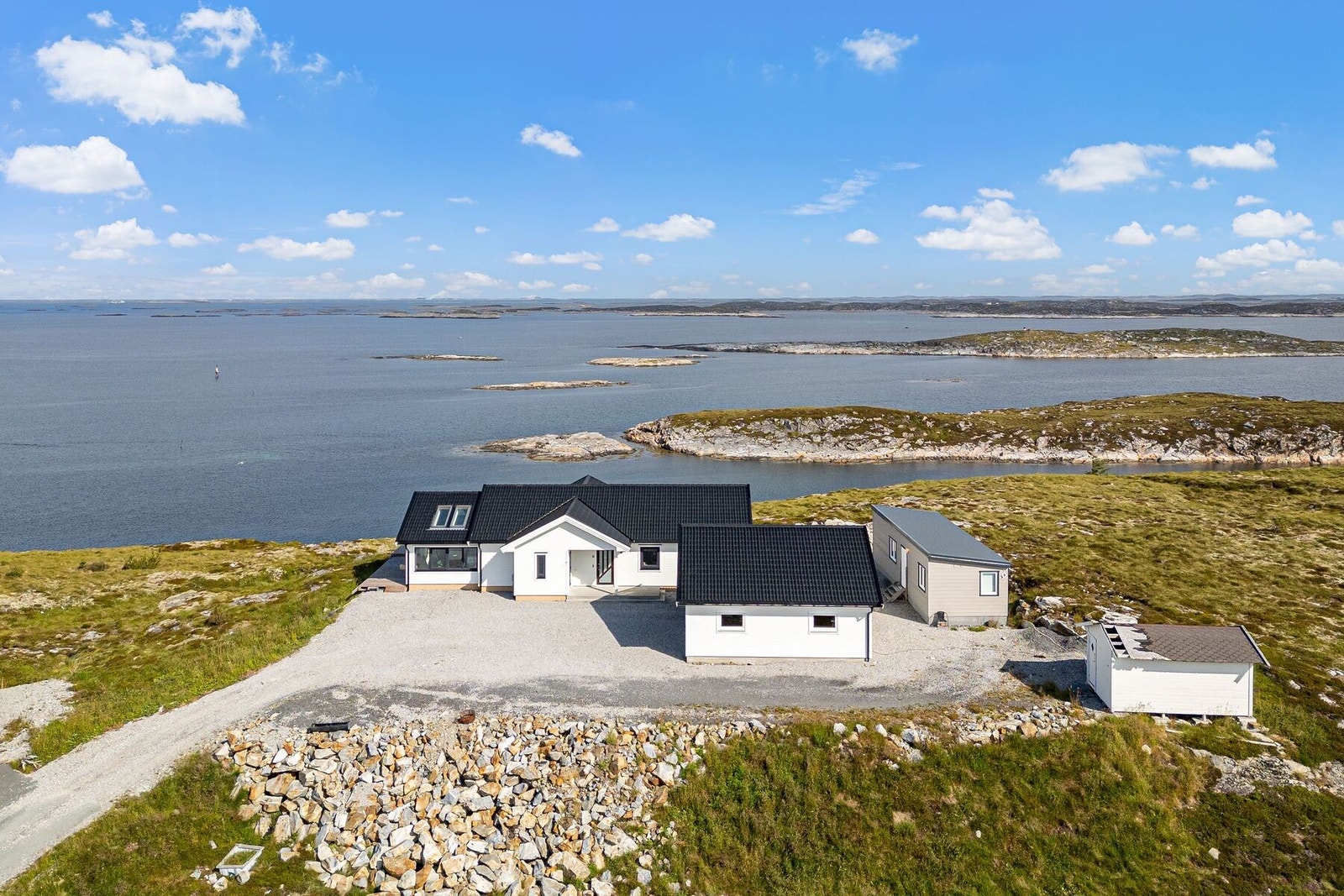 Eiendommen har tomt på 1058,1 kvm. opparbeidet med terrasser og parkeringsplass. De to byggene til høyre vil bli fjernet før salg. Galleribilde