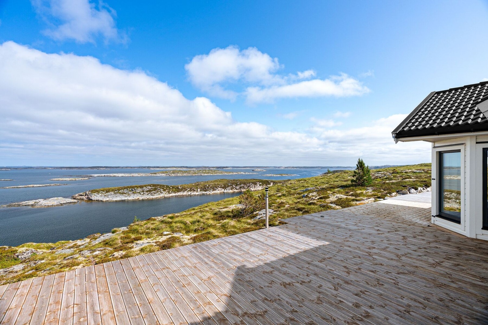 Terrassen strekker seg rundt store deler av boligen Galleribilde