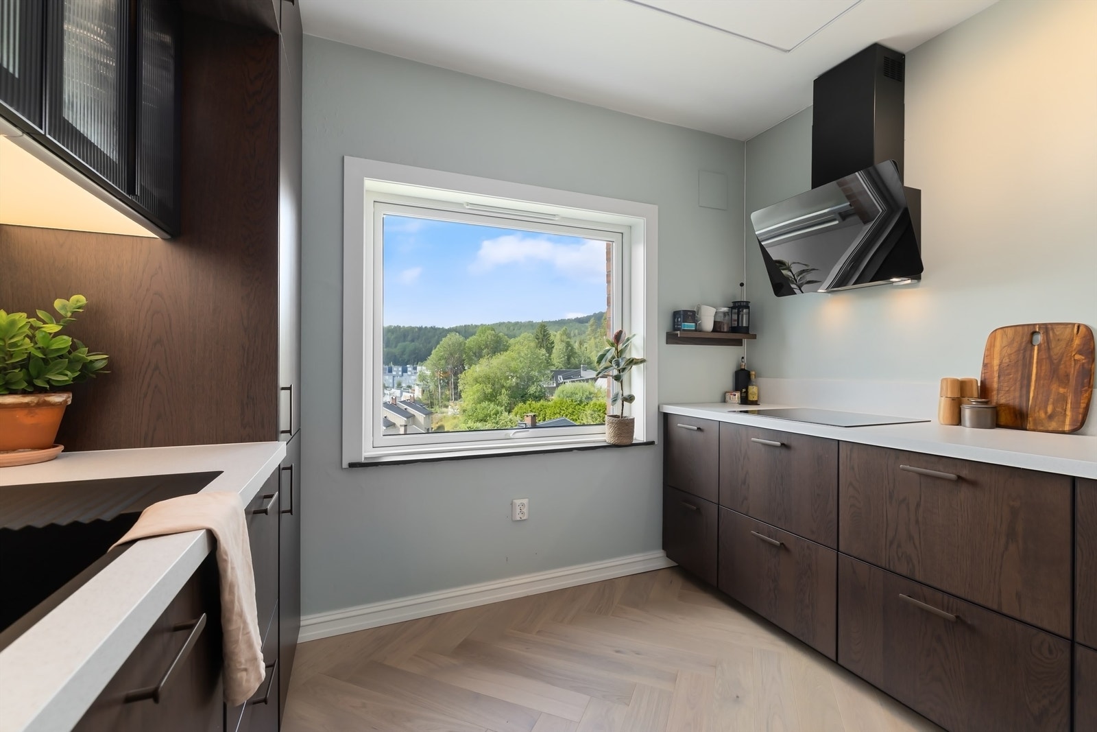 Kjøkkeninnredning fra Ikea med slette, mørke fronter, benkeplater av lys laminat og planlimt oppvaskkum med ett-greps armatur Galleribilde