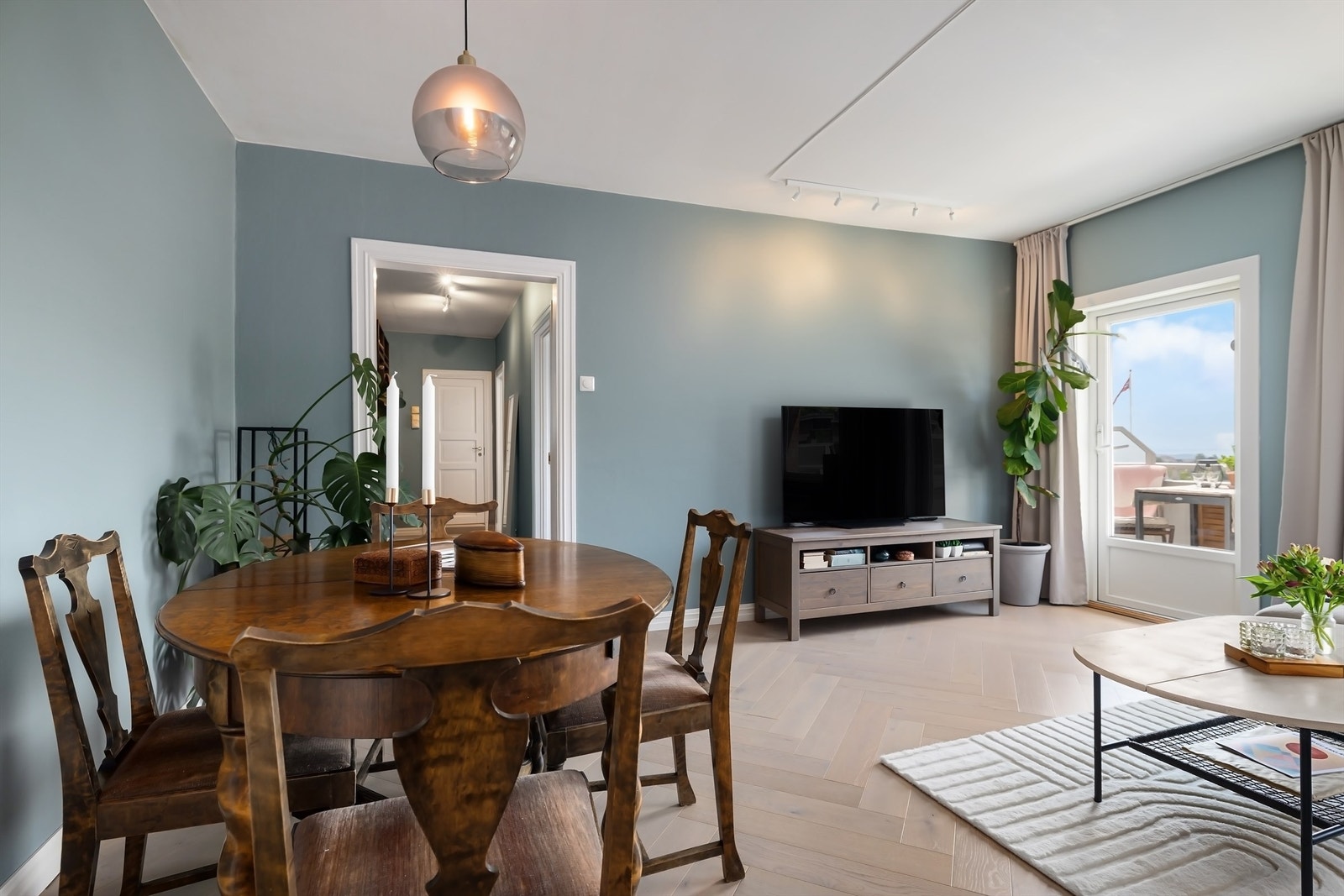 Stuen er malt i lyse farger på vegg og gulvet er belagt med en lys, klassisk fiskebensparkett Galleribilde