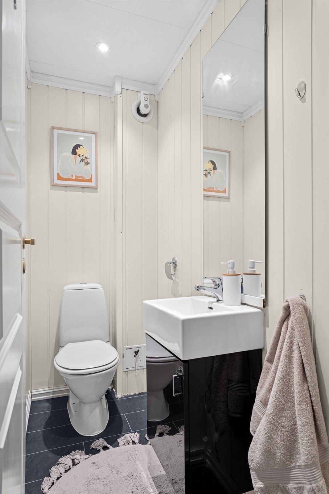 Toalettrommet er utstyrt med en servant med ett-greps blandebatteri og et vegghengt toalett. Galleribilde