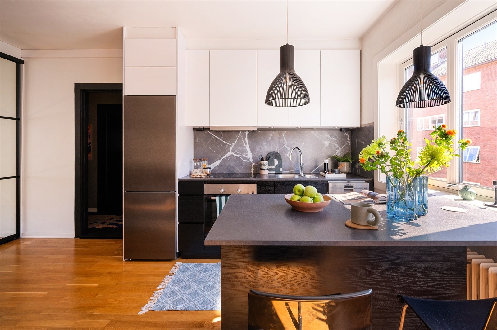 Stilren kjøkkeninnredning med mørke, glatte fronter og laminert benkeplate med nedfelt vaskekum. Galleribilde