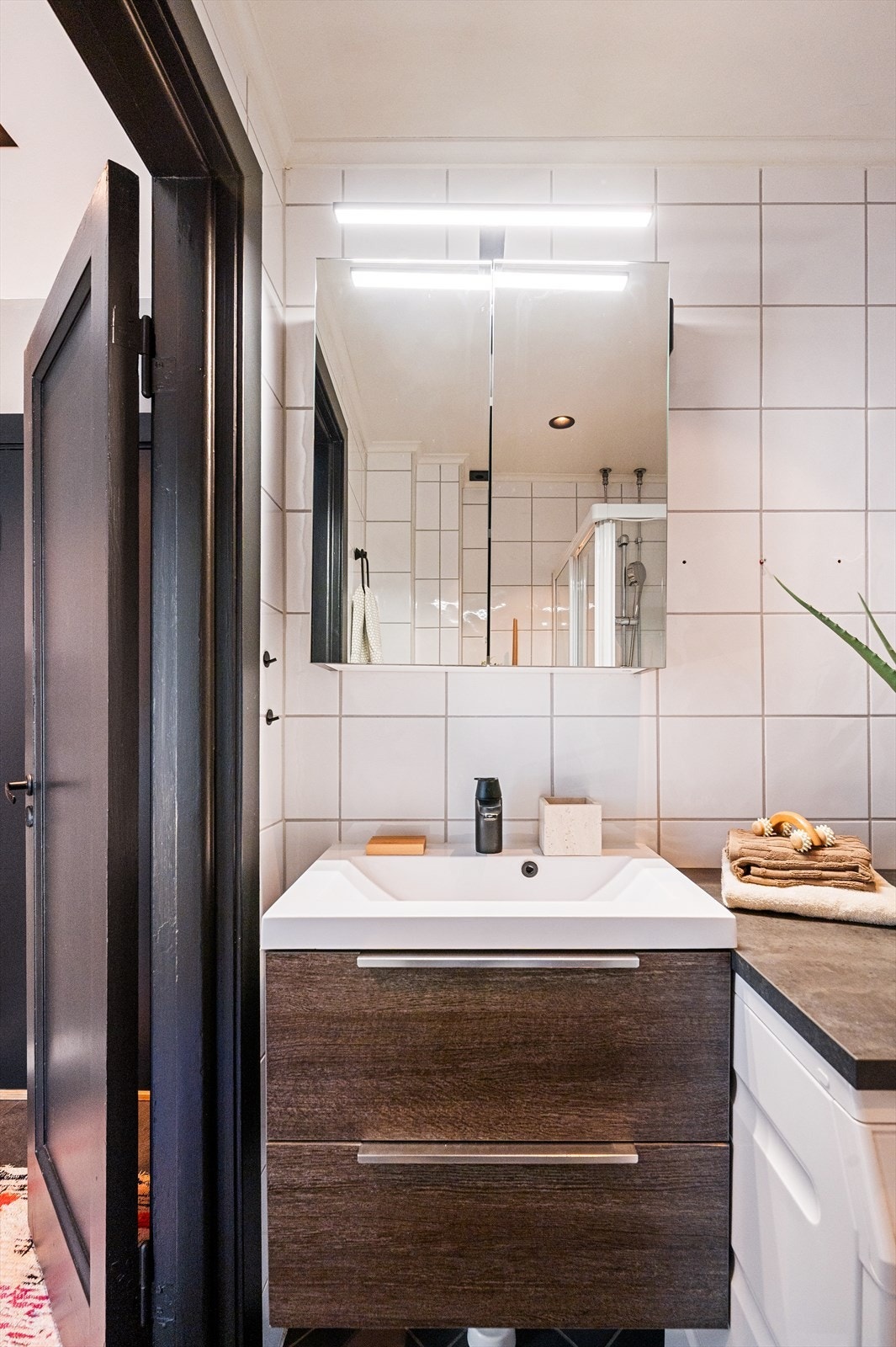 Rommet er innredet med vegghengt toalett, servant med underskap og dusjhjørne med glassvegger. Galleribilde