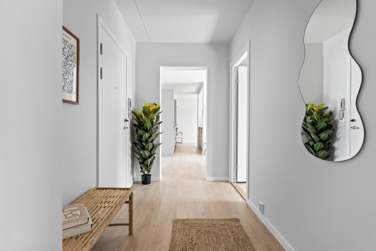 En innbydende entré med pent oppgradert enstavs laminatgulv og lyse, nøytrale vegger som harmonerer med resten av leiligheten. Galleribilde