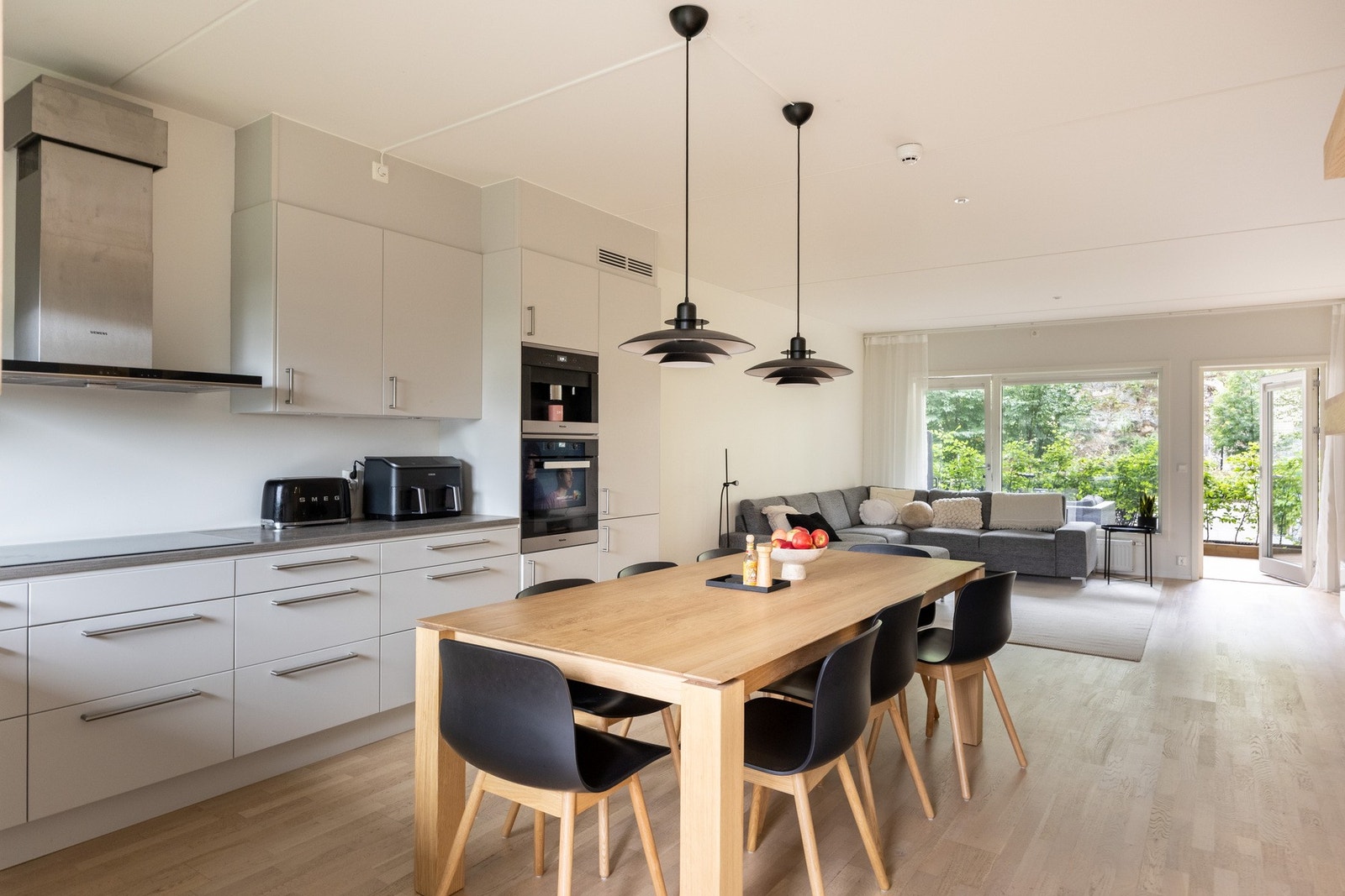 Den åpne løsningen mellom stuen og kjøkkenet skaper et sosialt allrom med rom for hele familien. Galleribilde