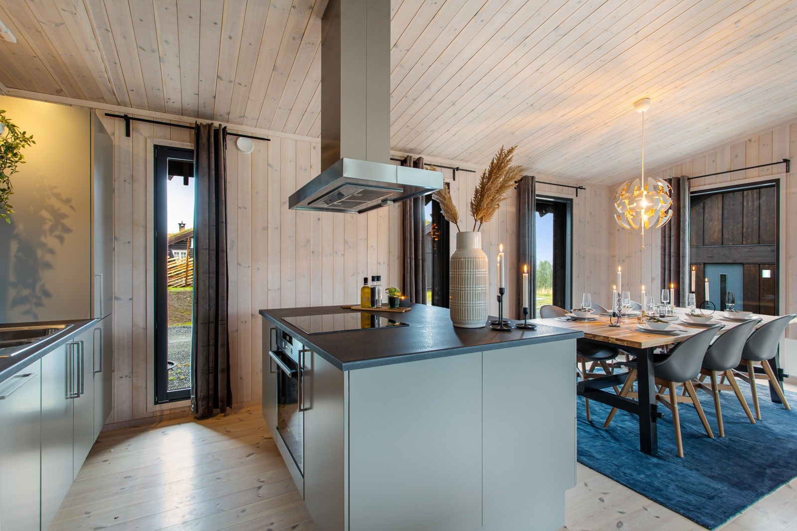 God plassutnyttelse med praktisk og vakker kjøkkenøy. Integrerte hvitevarer som komfyr, platetopp, kjøleskap med frysedel Galleribilde