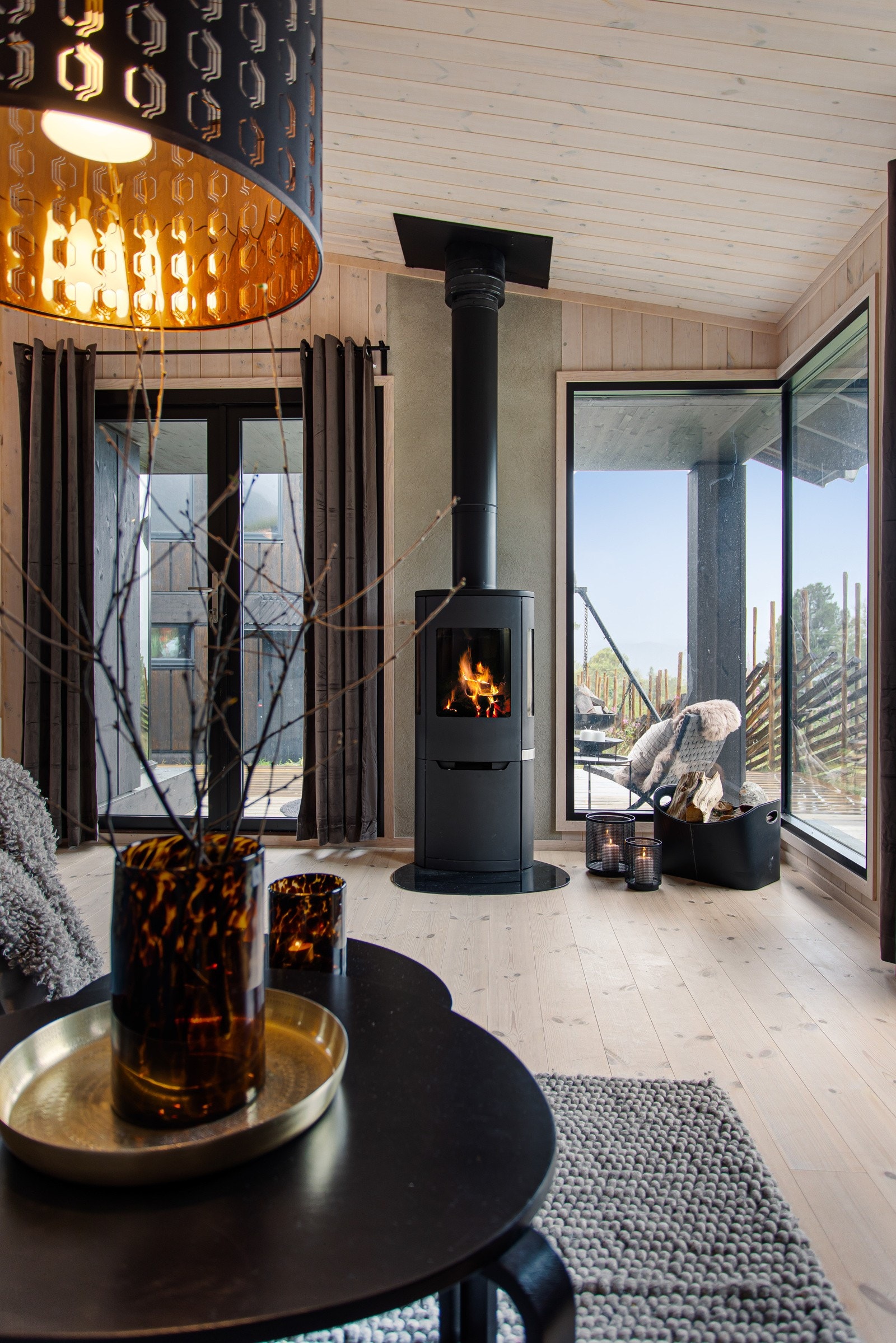 Sentralt i rommet står en lekker peisovn. Ellers har hytta varmestyring via Defa, som gir god komfort Galleribilde