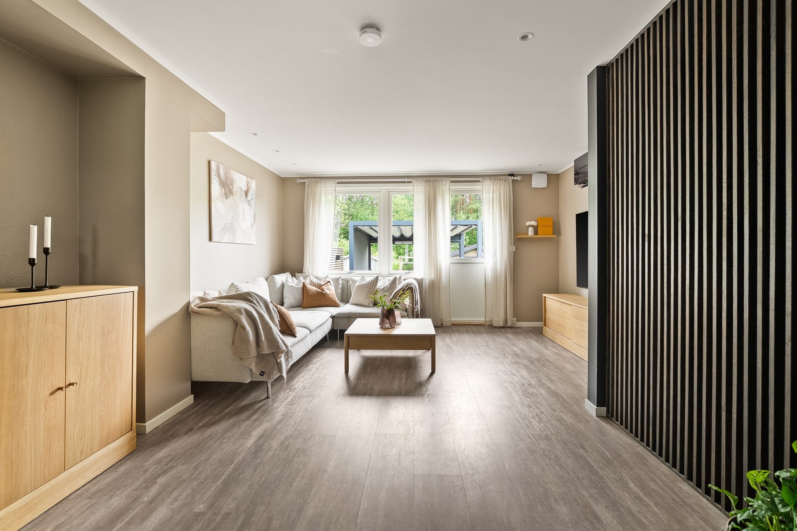 Romslig og innbydende stue med moderne overflater og en luftig, åpen løsning mot kjøkkenet. Galleribilde