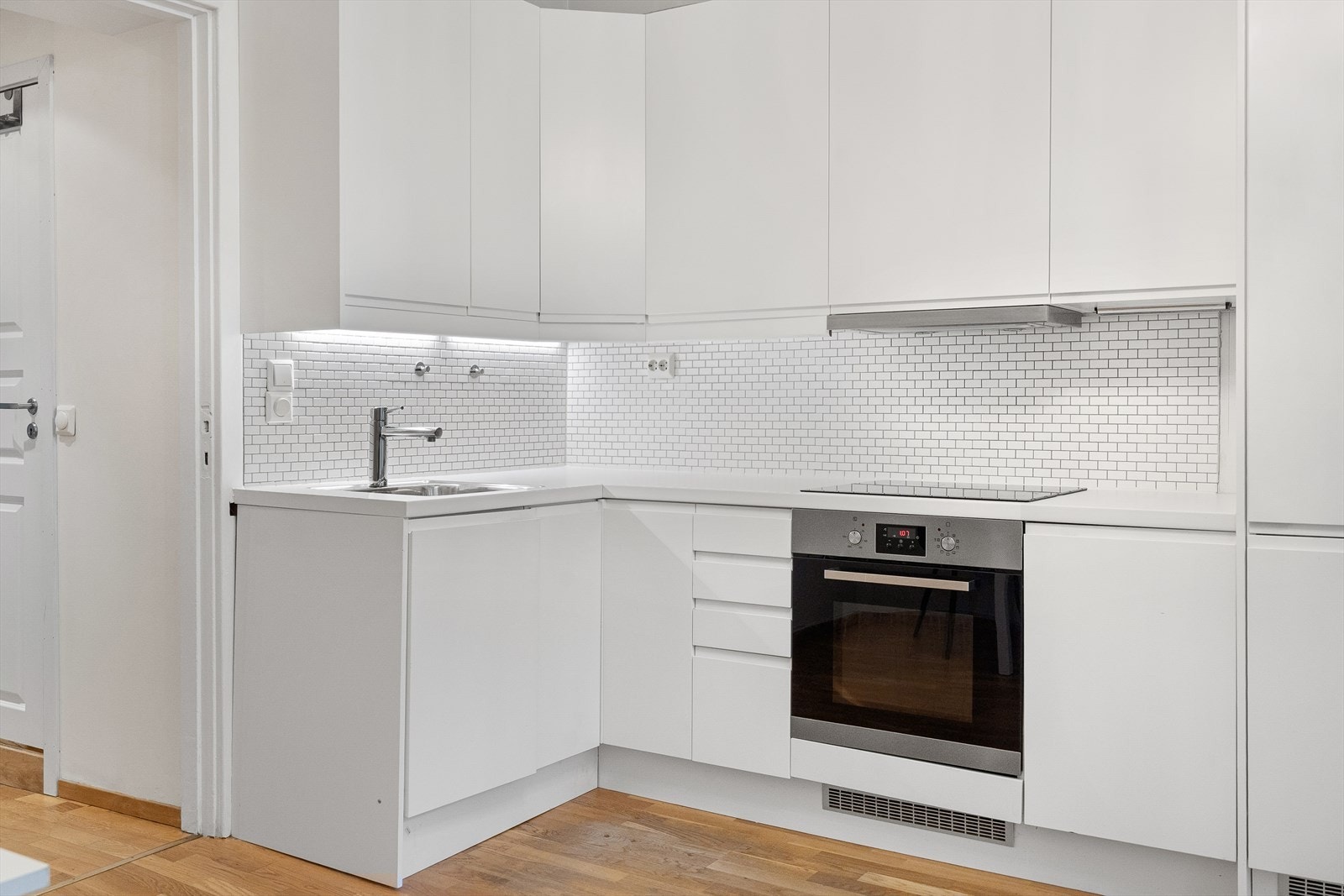 Pent kjøkken med mye oppbevaringsplass og stor arbeidsflate. Galleribilde