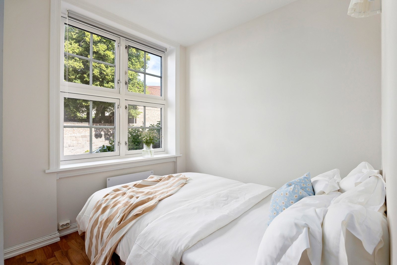 Lyst og rolig soverom med store vindusflater som slipper inn godt med naturlig dagslys og gir utsyn mot grønne omgivelser. Galleribilde