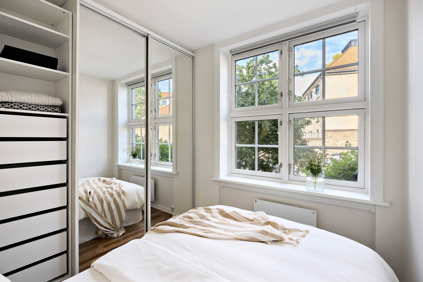 Praktisk skyvedørsgarderobe med speilfronter gir både god oppbevaringsplass og en romfølelse som forsterkes av lyset og de lyse overflatene. Galleribilde