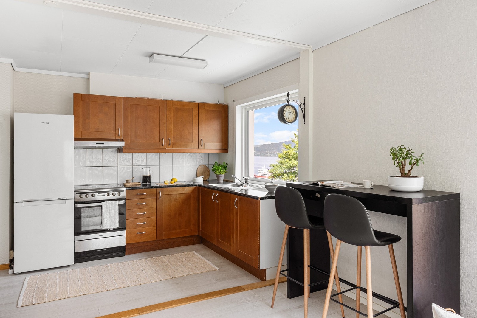 Kjøkkenet ligger i forlengelsen av stuen og har en praktisk og tidløs innredning med profilerte fronter og laminat benkeplate med nedfelt stålvask. Galleribilde