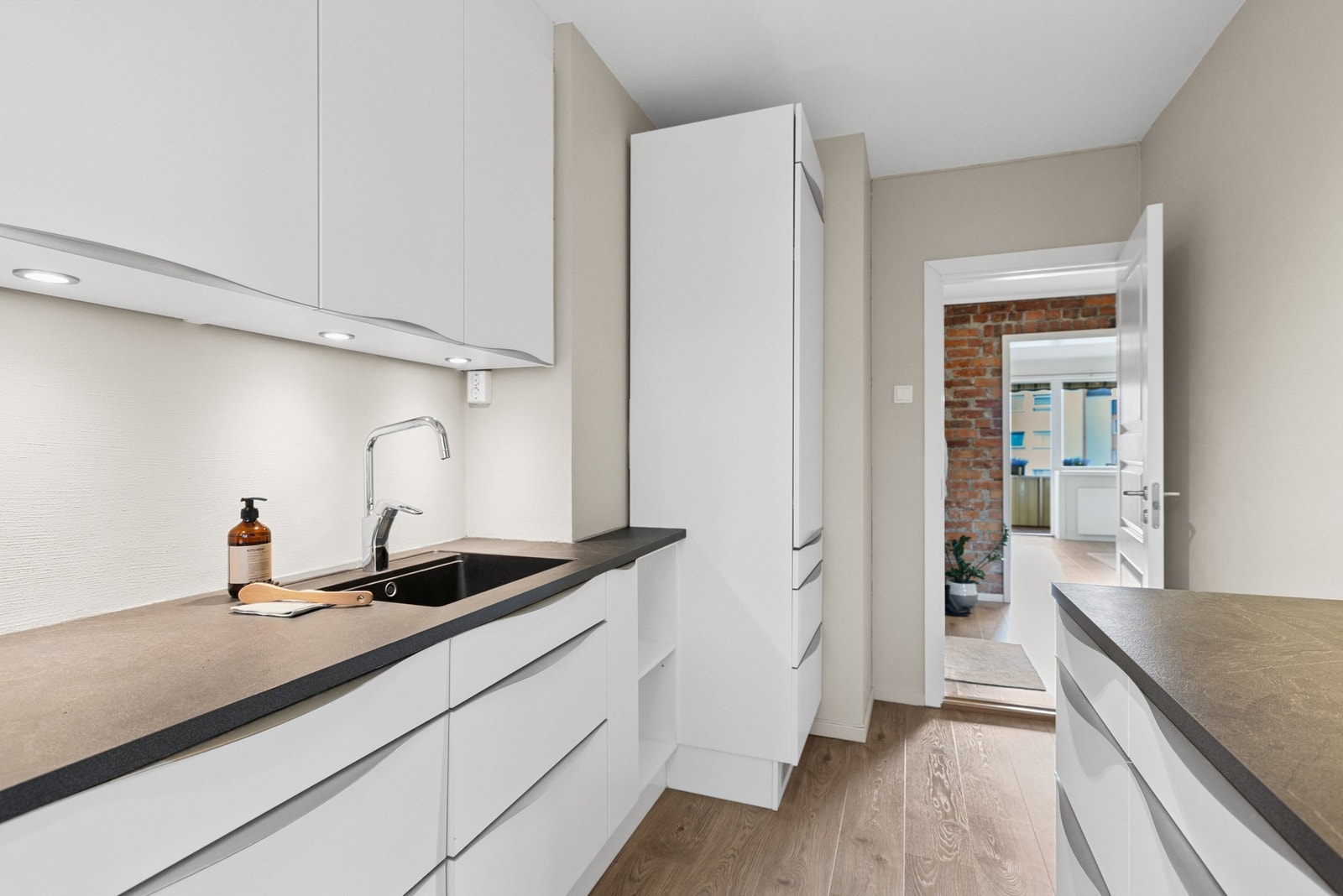 Kjøkkenet har et moderne og sømløst uttrykk med integrert oppvaskmaskin, kjøl/fryseskap, stekeovn og induksjon platetopp. Galleribilde