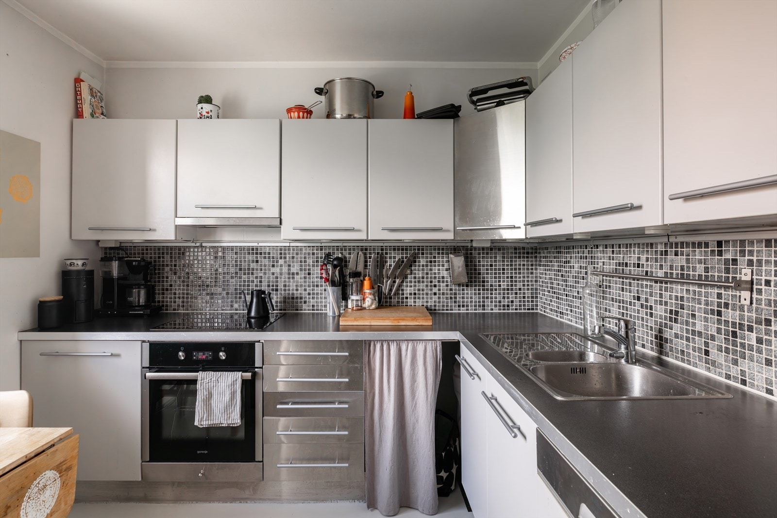 Lyst og funksjonelt kjøkken med god skap- og benkeplass. Kjøkkenet er utstyrt med integrert stekeovn, platetopp og oppvaskmaskin, samt kullfiltervifte over stekesonen. Det er også opplegg for oppvaskmaskin. Galleribilde