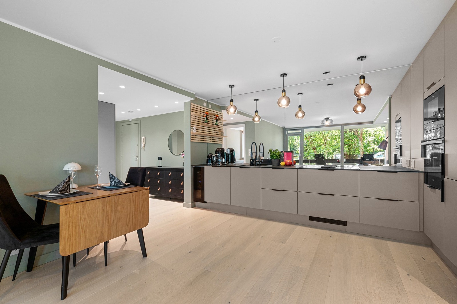 Kjøkkenet har en praktisk og fin åpen løsning mot stuen med naturlig plass til spisebord. Galleribilde