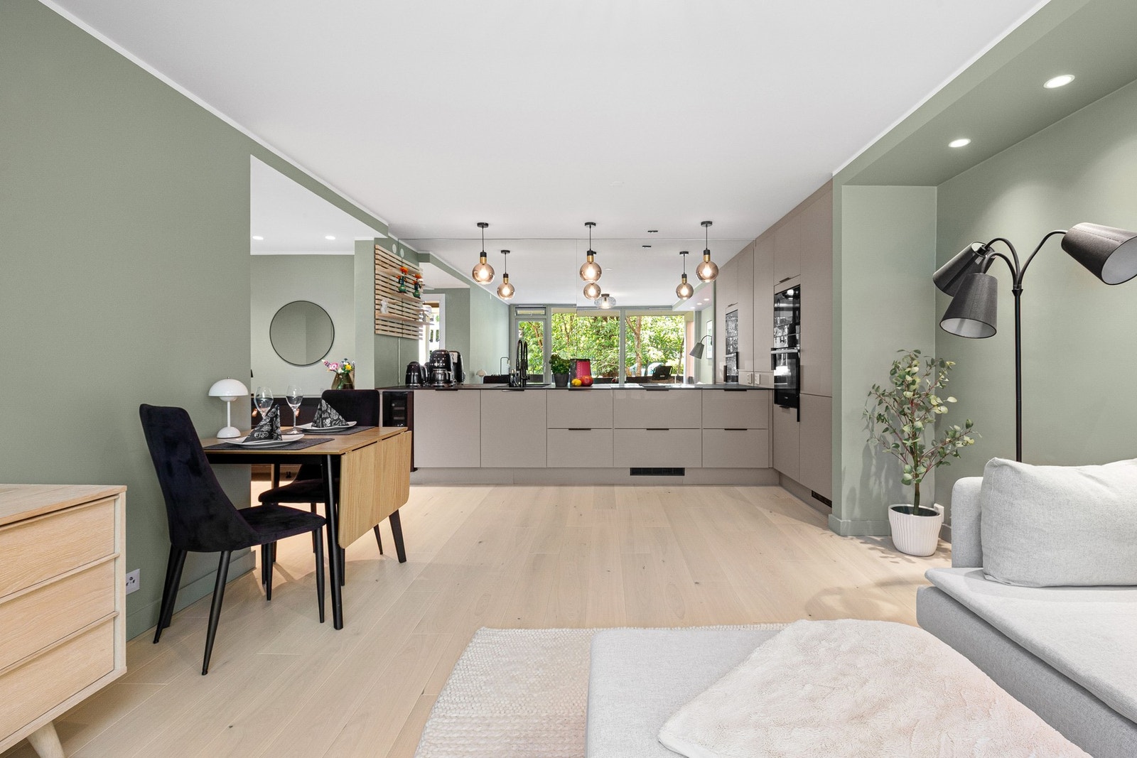 Den åpne løsningen mellom stue og kjøkken gjør rommet som et naturlig samlingssted for venner og familie. Galleribilde