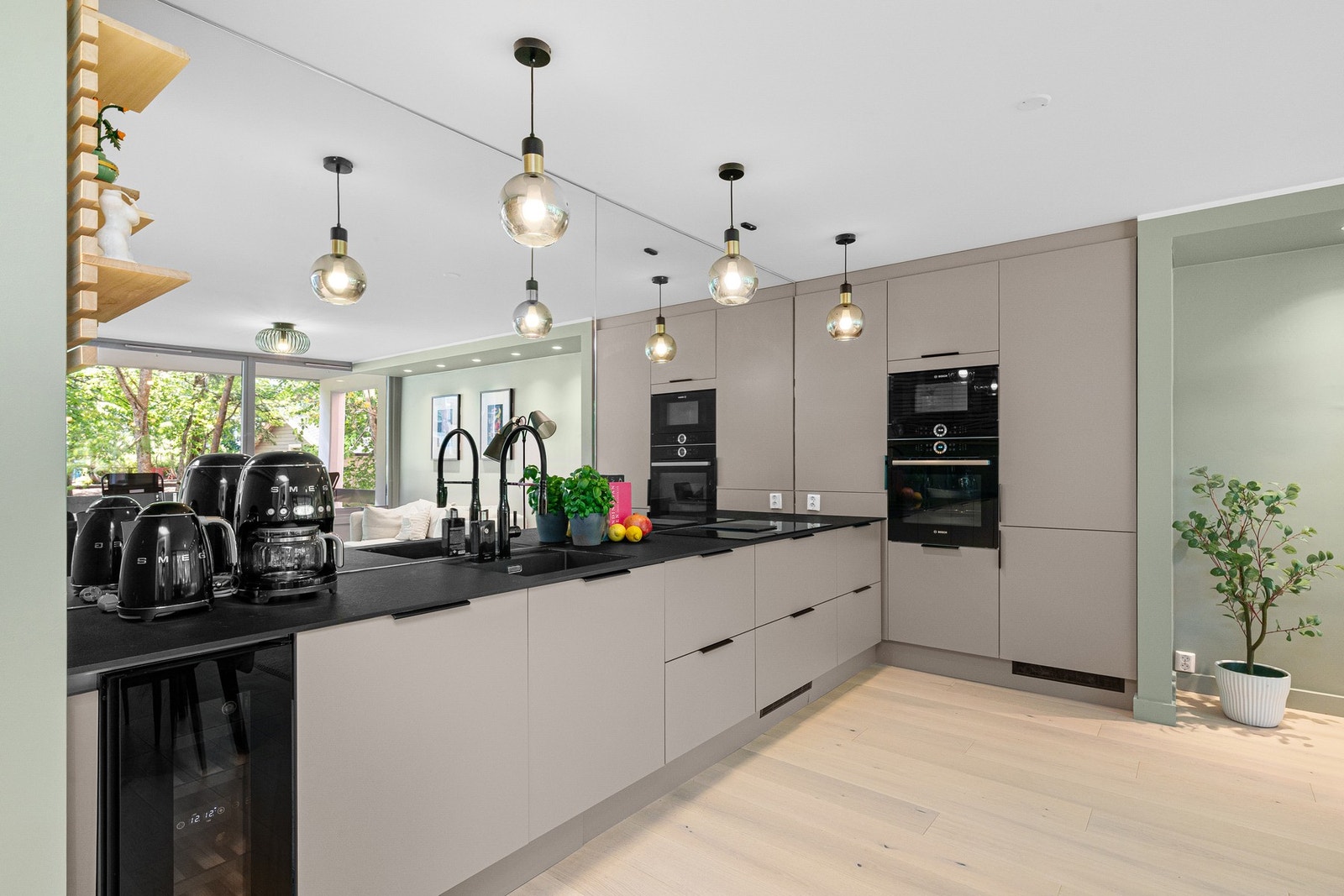 Lekker speilvegg over benkeplate som skaper en wow-følelse og reflekterer lyset i boligen. Galleribilde