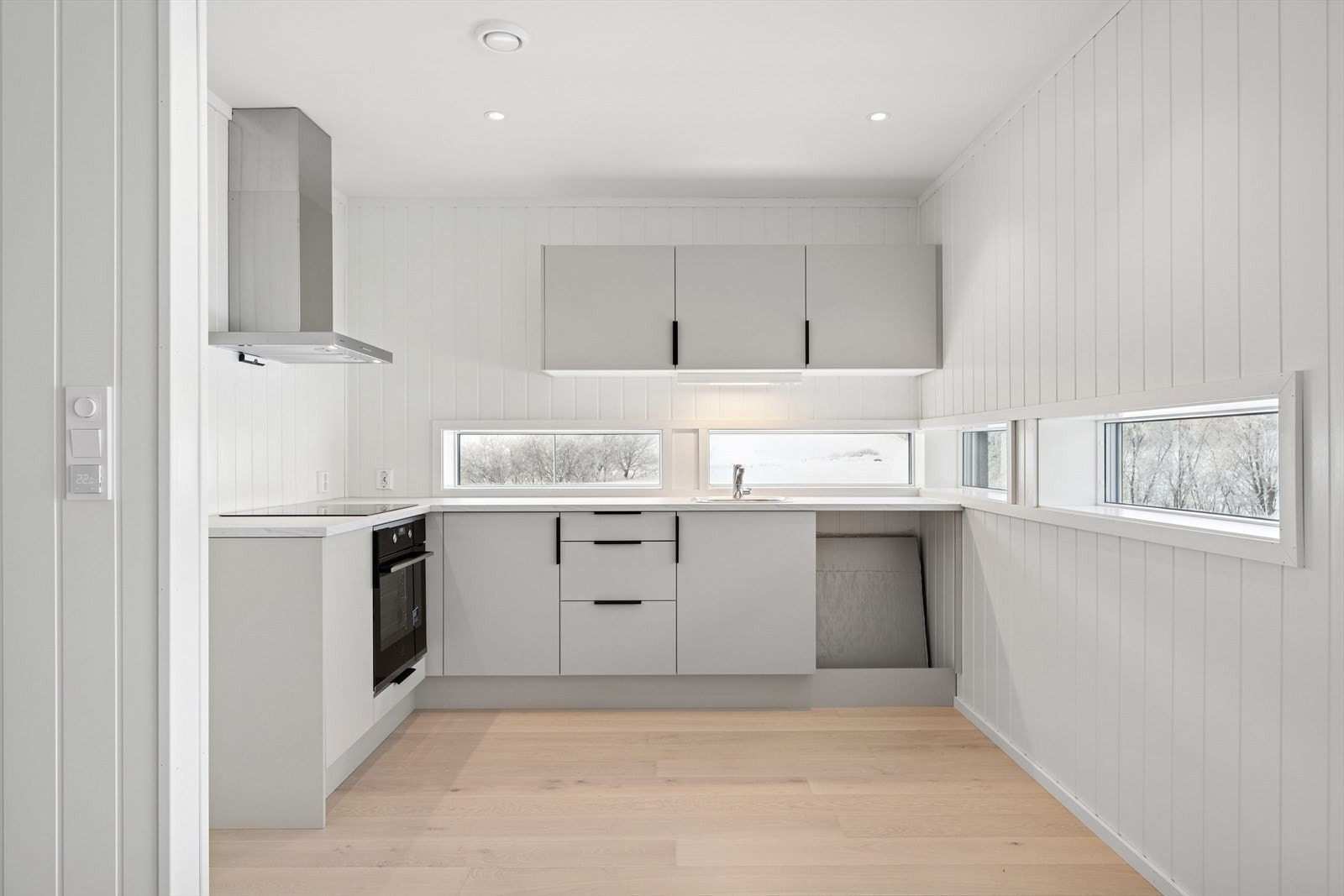 Kjøkkenet er fra Sigdal, med grå glatte fronter, integrert komfyr, nedfelt platetopp og benkeplate i laminat. Galleribilde