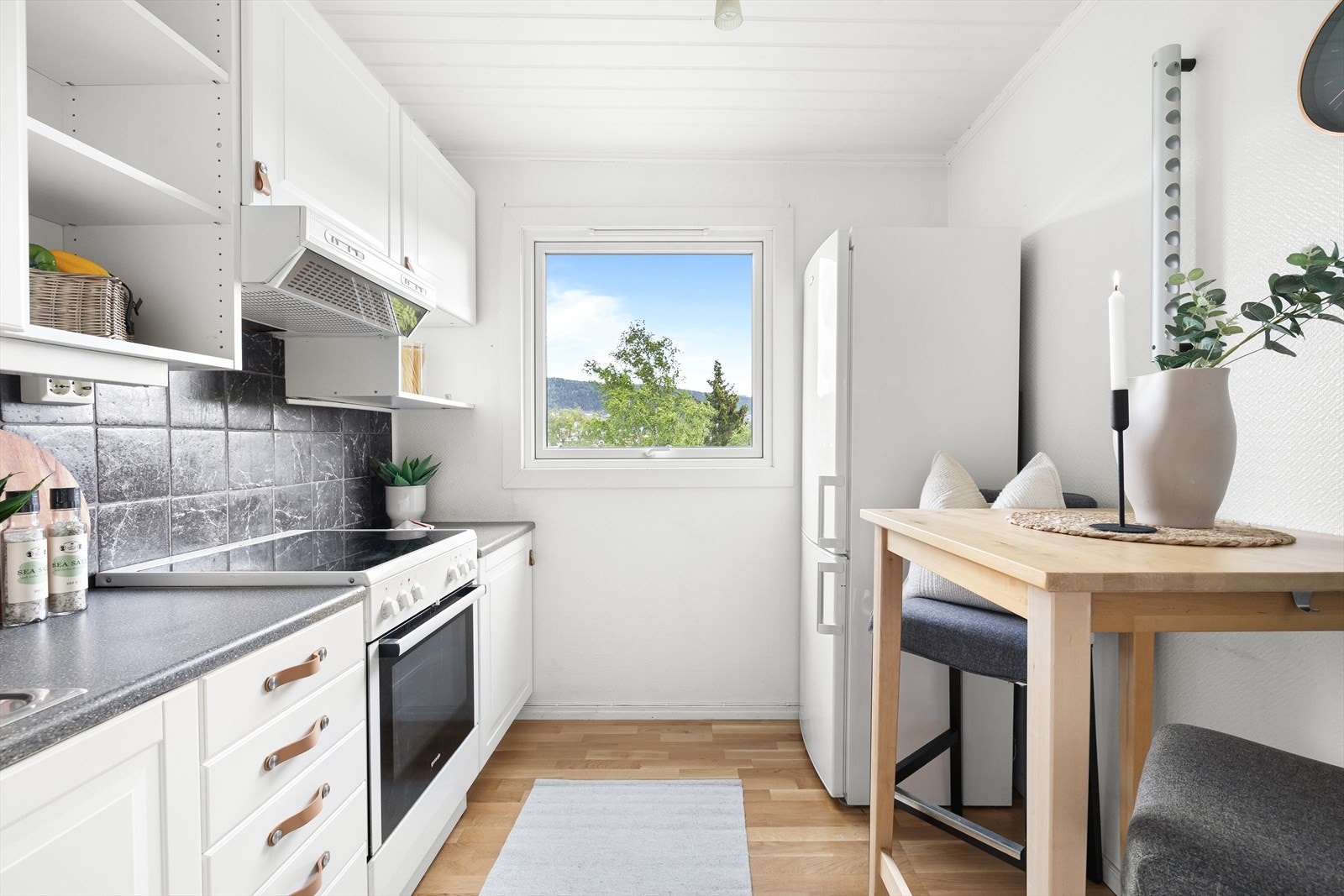 Benkeplaten er i laminat med nedfelt vask, og over kokeplassen er det montert kullfilterventilator. Galleribilde