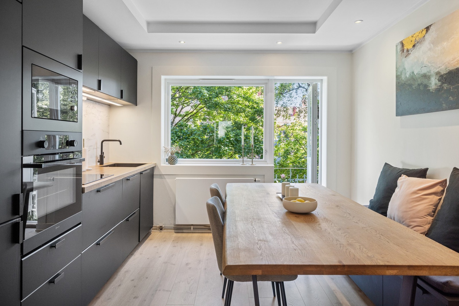 Stilren innredningen fra 2021 med glatte, mørke fronter og benkeplate i slitesterk laminat. Galleribilde